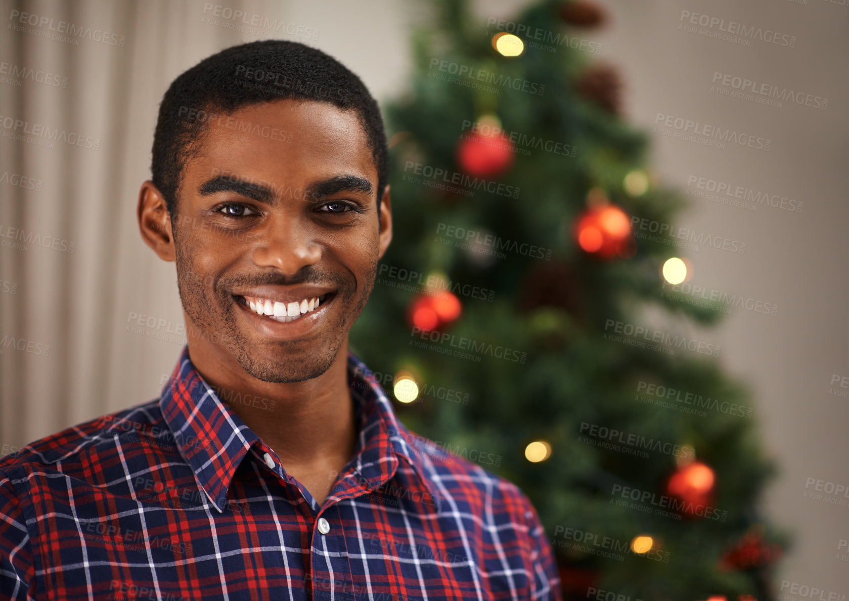 Buy stock photo Shot of a handsome young man getting into the Christmas spirit