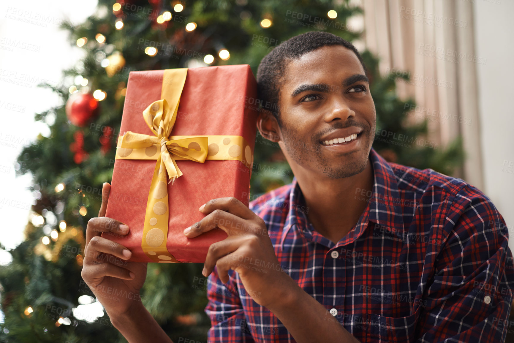 Buy stock photo Shot of a handsome young man getting into the Christmas spirit