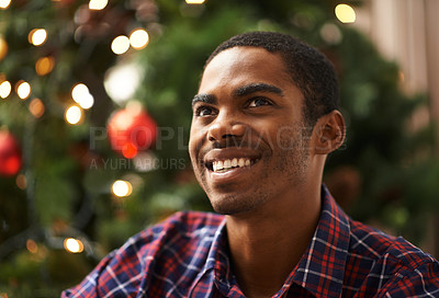 Buy stock photo Man, thinking and happy in home on christmas for celebration, holiday and festive spirit in living room. African person, thoughtful and smile on xmas with relax, confidence and vacation in apartment