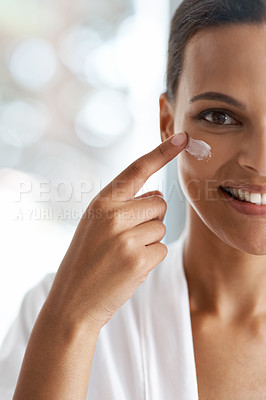 Buy stock photo Closeup portrait of a gorgeous young woman applying moisturizer to her skin
