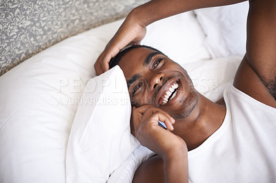Buy stock photo Happy, black man and lying in bed with phone for communication, conversation or networking at home. Face of African male person with smile on mobile smartphone for discussion or relax in the bedroom
