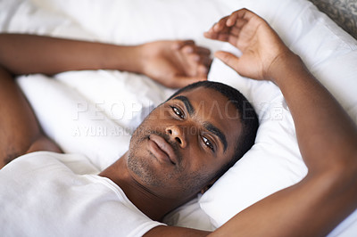 Buy stock photo Black man, portrait and morning with bed in relax for wakeup, comfort or resting on duvet or sheets at home. Face of African male person lying awake in bedroom with pajamas for weekend at the house