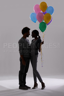 Buy stock photo Couple, silhouette and party with balloons for celebration, event or romance on a gray studio background. Man and woman holding colorful objects of helium for art, date or anniversary on mockup space