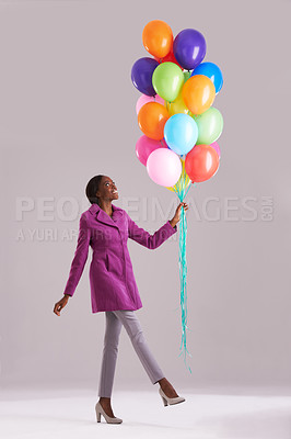 Buy stock photo Balloon, fashion and happy black woman in studio for birthday, celebration and present. Style, excited and isolated person smile with inflatables for party, gift and surprise on gray background
