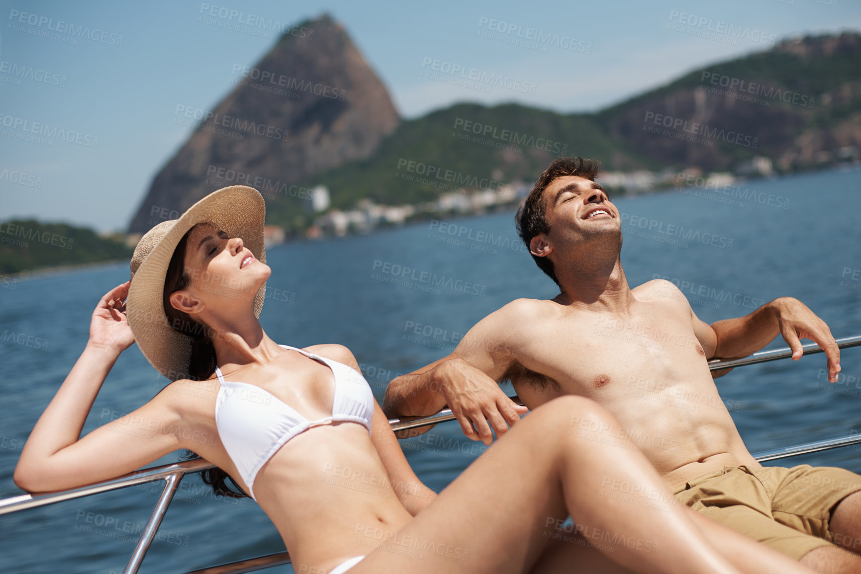 Buy stock photo Shot of an attractive young couple relaxing on a yacht together