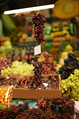 Buy stock photo Shot of hanging bunches of grapes at a market