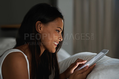 Buy stock photo Shot of a beautiful young woman relaxing in bed with her tablet
