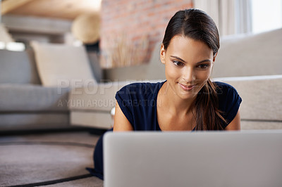 Buy stock photo Laptop, smile and young woman relaxing on carpet working on freelance project at home. Happy, technology and female person with computer for creative research laying on floor mat in living room.