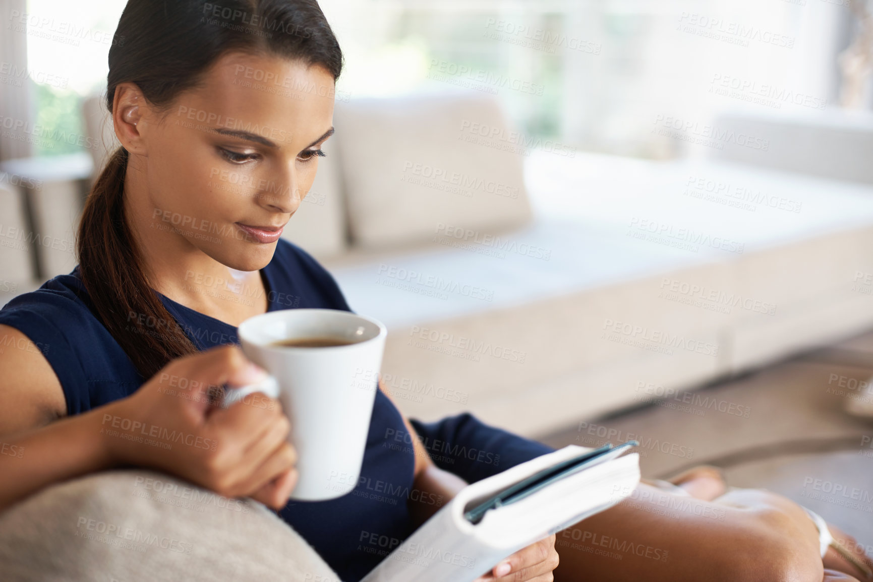 Buy stock photo Woman, drinking coffee and reading a book in home to relax, education or learning at breakfast in the morning in lounge. Novel, tea cup or person with espresso, latte and study on sofa in living room