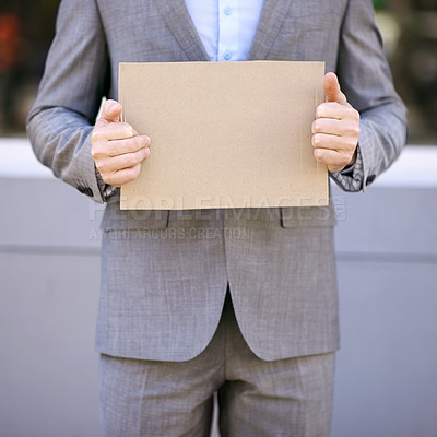 Buy stock photo Blank, cardboard and unemployment person with suit, poster and mockup for job hunting outdoor. Professional, hands and businessman sign to seek or search for work on street in city of Cape Town