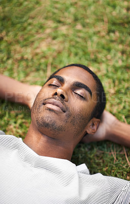 Buy stock photo Face, sleep and black man on grass in garden of summer home for peace, wellness or mindfulness. Nature, relax and filed with calm young person lying on green ground from above for break or rest