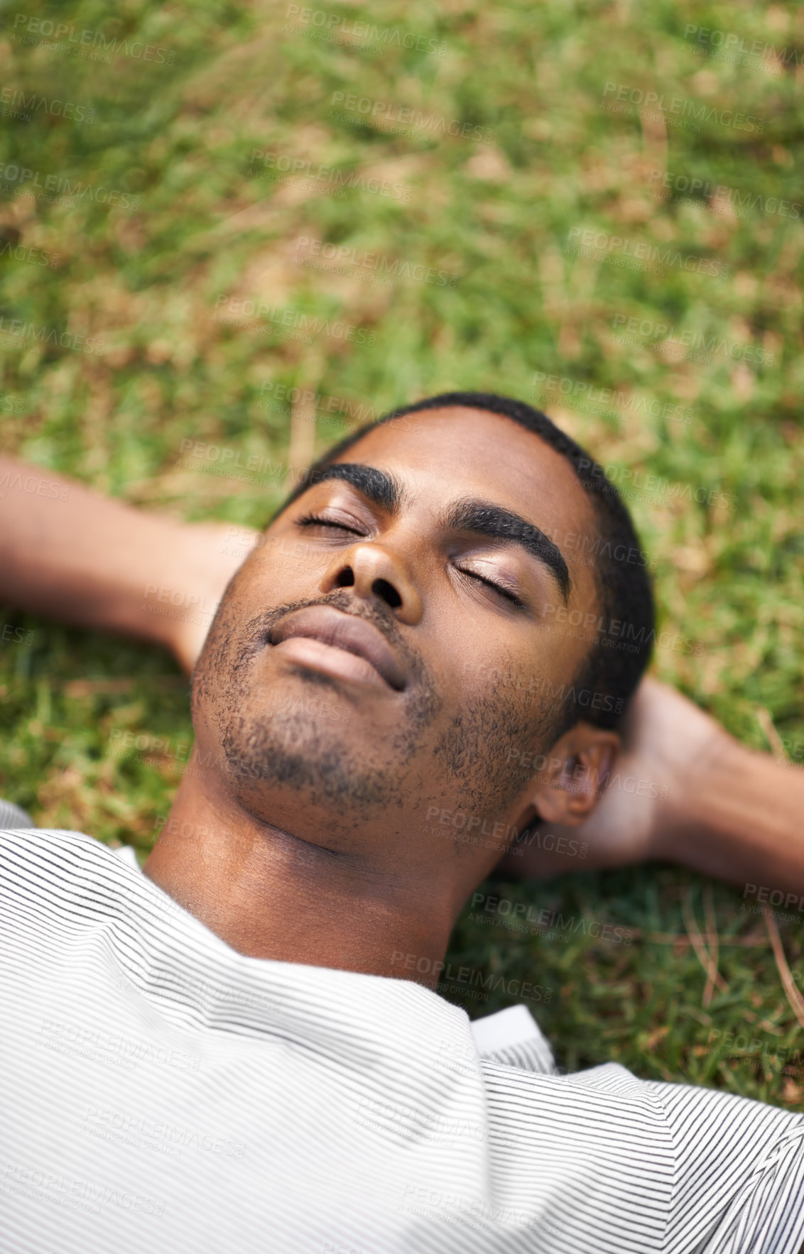 Buy stock photo Face, sleep and black man on grass in garden of summer home for peace, wellness or mindfulness. Nature, relax and filed with calm young person lying on green ground from above for break or rest