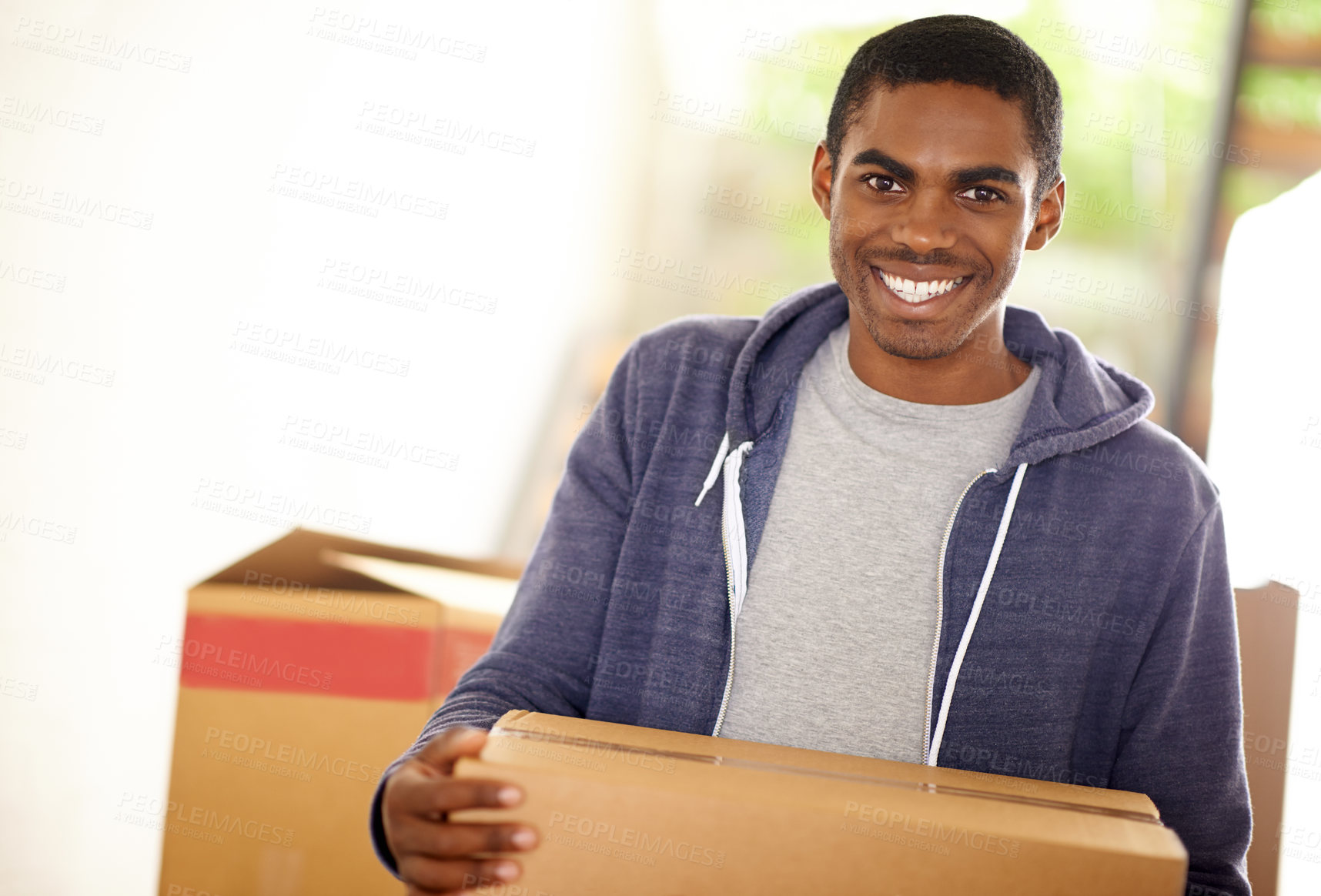 Buy stock photo A handsome young man packing boxes