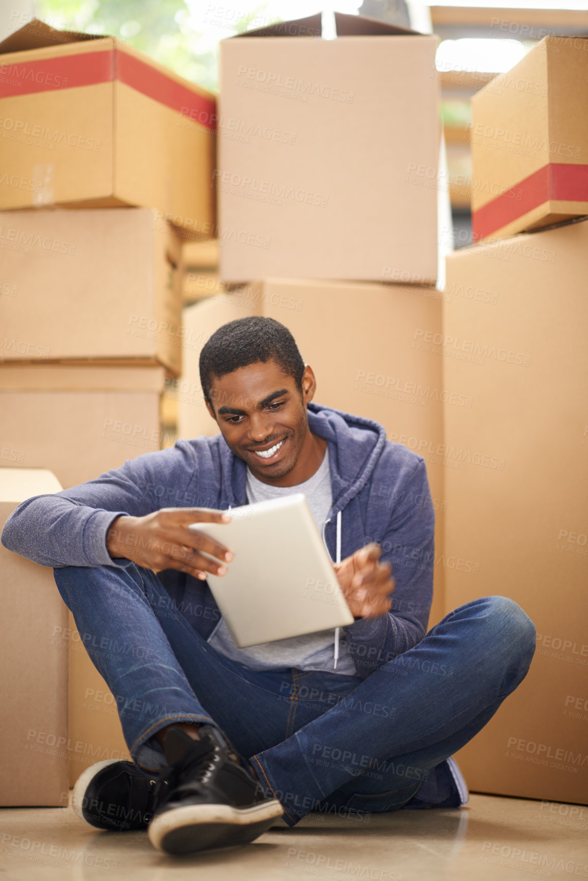 Buy stock photo Boxes, home and black man with a tablet, smile and typing with internet and package in lounge. African person on the floor, apartment and guy with tech or cardboard with communication and digital app