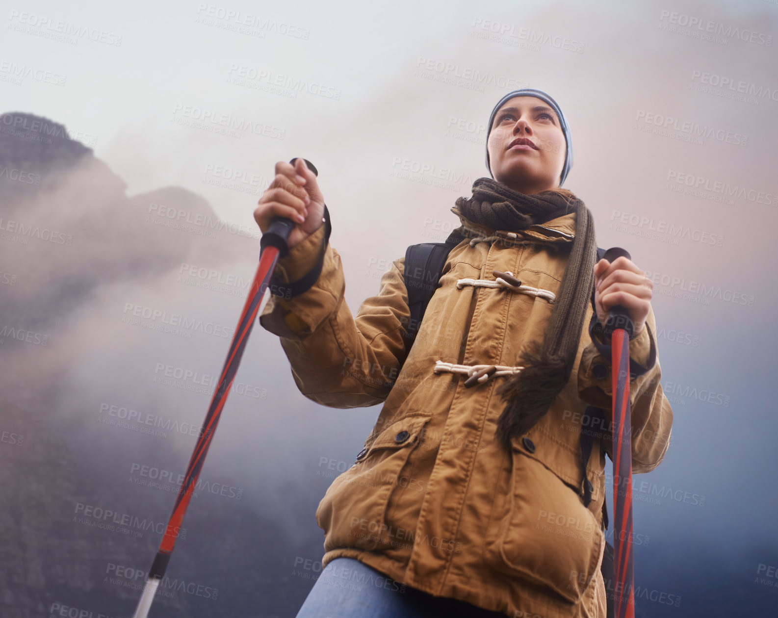 Buy stock photo Low-angle view of a young female hiker with the mountain in the background