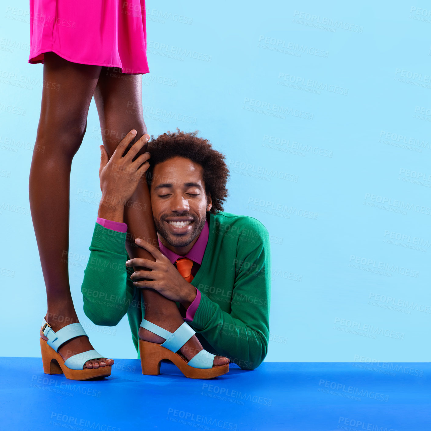 Buy stock photo Couple, studio and smile with color, fashion and love with relationship and begging. African man, woman and dating with funky, vivid and bright worship with vintage or confession on blue background