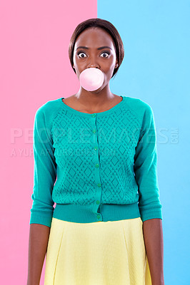 Buy stock photo Studio shot of an attractive young woman blowing a gum bubble against a colorful background