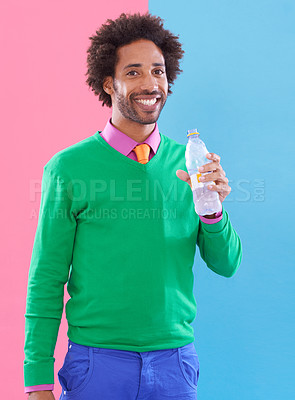 Buy stock photo Fashion, black man and smile in studio with water in bottle on color block background for health, hydration and wellbeing. Portrait, male person and happy with trendy outfit for style and formal. 