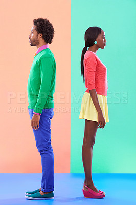 Buy stock photo Studio shot of a young couple standing against a colourful background