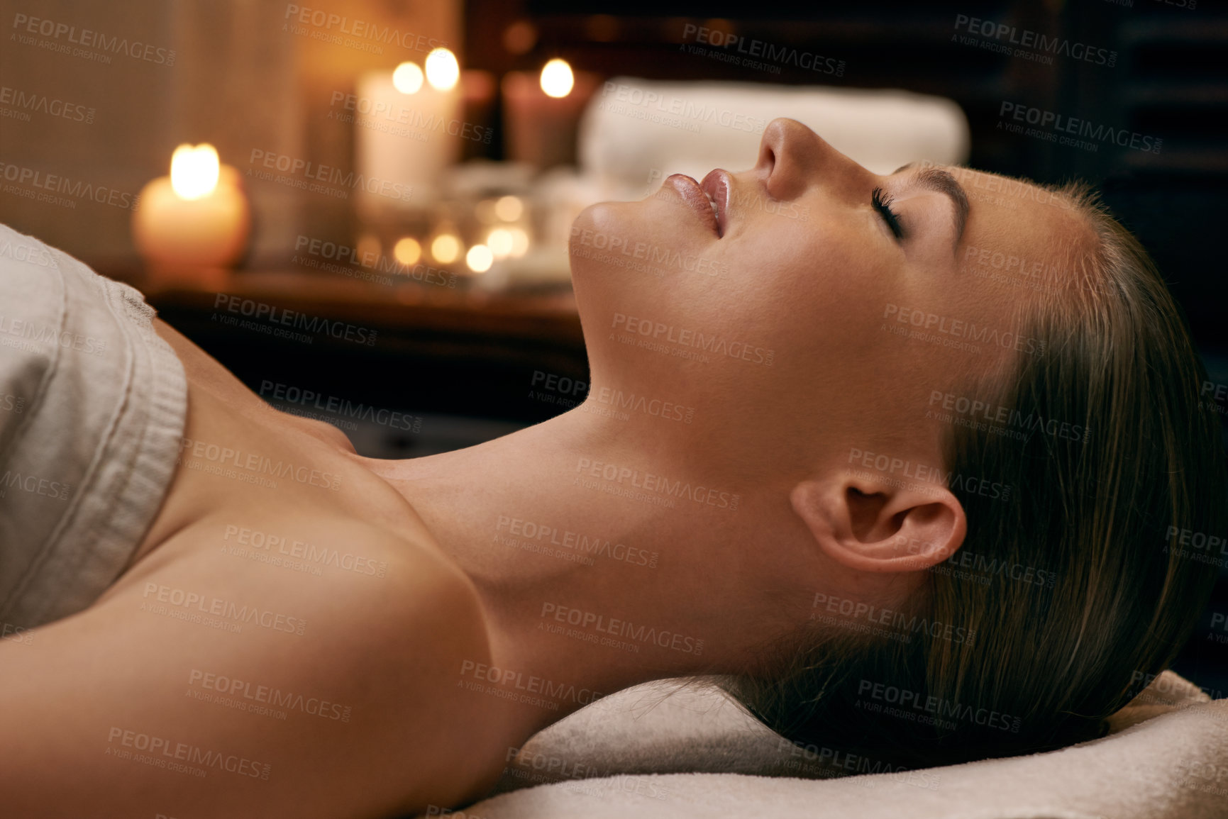 Buy stock photo A young woman lying with her eyes closed on a massage bed