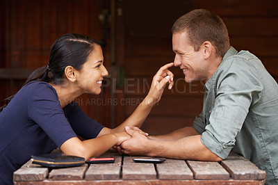 Buy stock photo Love, holding hands and couple at a cafe for date, bonding and fun with playful nose touching, smile or conversation. Care, romance and people at coffee shop happy with weekend, travel or chilling