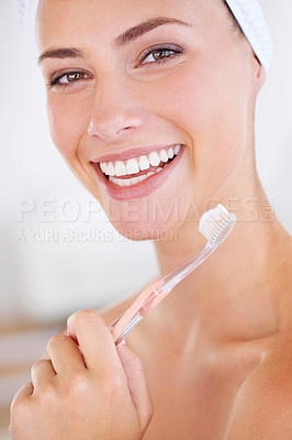 Buy stock photo A lovely young lady holding a toothbrush while smiling