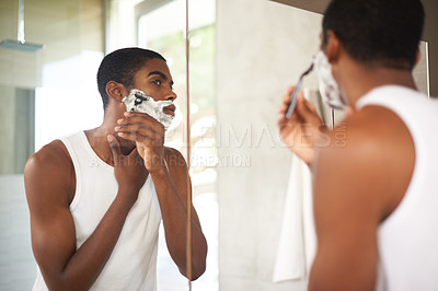 Buy stock photo Mirror, shaving or grooming and black man in bathroom of home with razor for morning hair removal. Face, skincare and reflection of young person with foam to shave beard for hygiene routine 