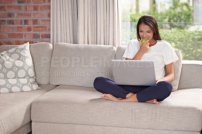 Buy stock photo Laptop, eating apple and a woman on a home sofa with internet for streaming, remote work and reading blog online. Happy female person relax on couch with fruit, snack and computer for elearning tech