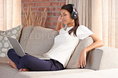 Buy stock photo Laptop, headphones and woman on a home sofa listening to music or streaming movies online. Calm female person relax on couch to listen to radio or video with internet connection and technology