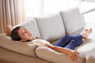 Buy stock photo Portrait of an attractive young woman relaxing on the couch at home