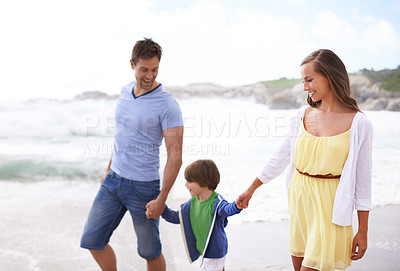 Buy stock photo Family, child and holding hands while walking at beach for travel, fun or holiday in summer with a smile. Man, woman and kid or son walk together on vacation at sea with happiness, love and care