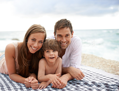 Buy stock photo Beach, family and portrait outdoor in summer on a picnic blanket for travel vacation to relax. Smile of a man, woman and child or son happy together on holiday at sea with love, care and happiness
