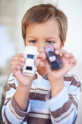 Buy stock photo Portrait of a little boy playing with toy cars