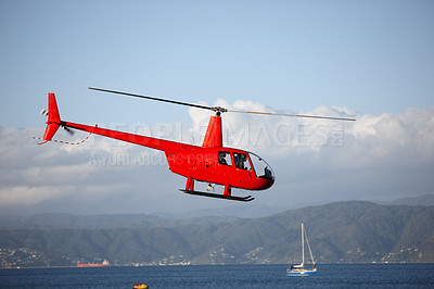 Buy stock photo Helicopter, sea and emergency transport or landscape for search and rescue, medical service or patrol in sky. Chopper, aerial view and ocean environment for help on mountain, coast guard or lifesaver