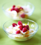 A photo of dessert - raspberries, banana and cream