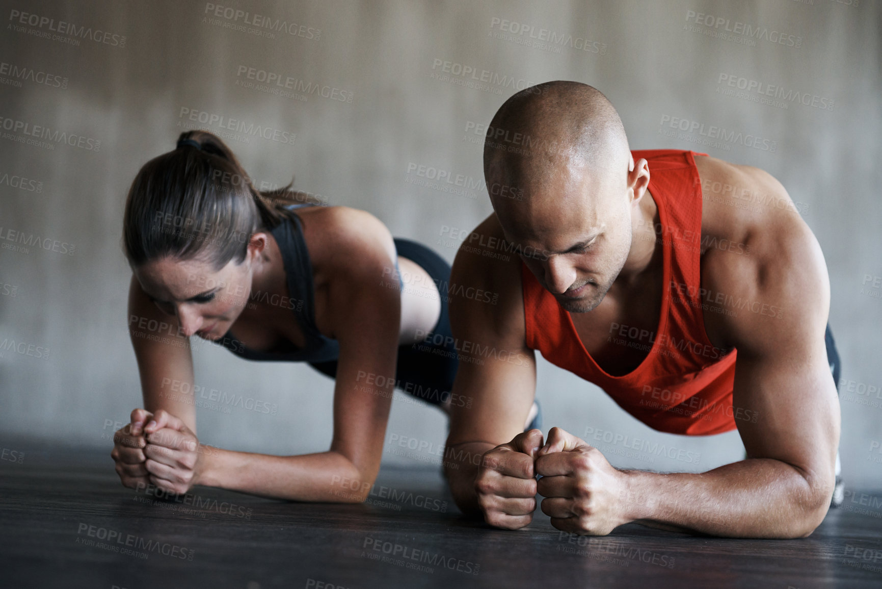 Buy stock photo Shot of a man and woman doing plank exercises at the gym