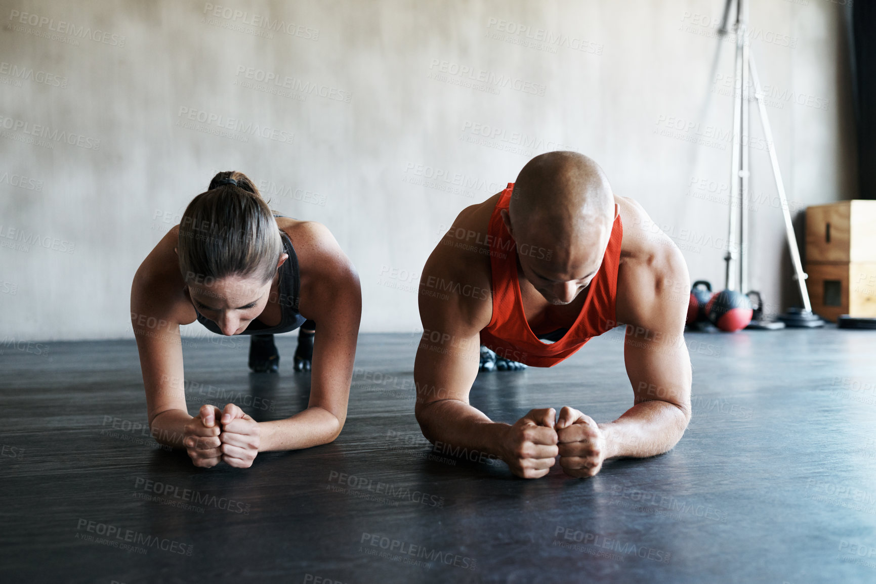 Buy stock photo Shot of a man and woman doing plank exercises at the gym