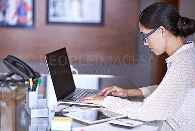 Buy stock photo Shot of a beautiful young woman working on her laptop