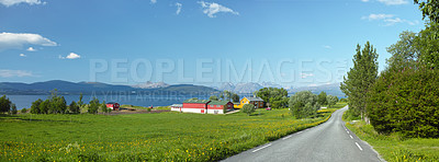 Buy stock photo Mountain, road trip and ocean village with travel, holiday and countryside scenery in Norway. Nature, blue sky and highway for journey, vacation and outdoor adventure with lake houses, trees and bush