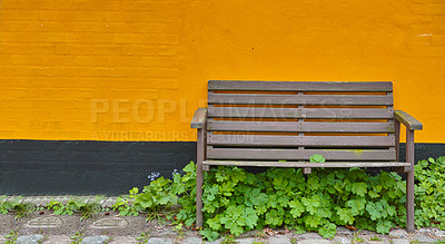 Buy stock photo A single wooden bench against a bright orange wall