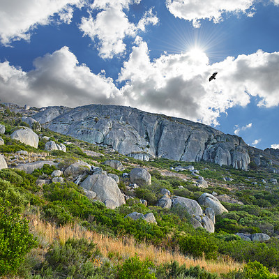 Buy stock photo Mountains, environment and blue sky with nature, birds and stone with landscape and vacation. Empty, rocks and grass with flowers or countryside with summer or animals with sunshine, growth or spring