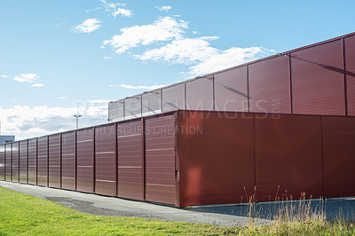 Buy stock photo Red metal boxes for temporary storage and room for building material. A modular cladded storage facility. Portable office containers or prefabricated modular buildings for construction workers on site