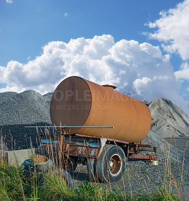 Buy stock photo Old water tanker decaying at construction site. Rusted water container near a heap of concrete and cement. Abandoned old rusty water trailer tank near a pile of sand and gravel in building industry