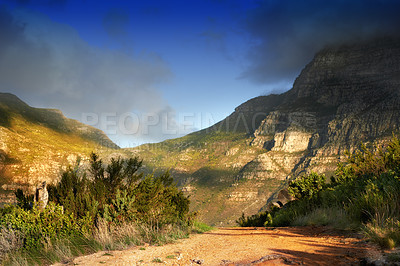 Buy stock photo Mountains, nature and clouds in sky for travel, hiking and eco friendly tourism with dirt road, path or trail. Background of environment, landscape and bush in summer for biodiversity in Cape Town