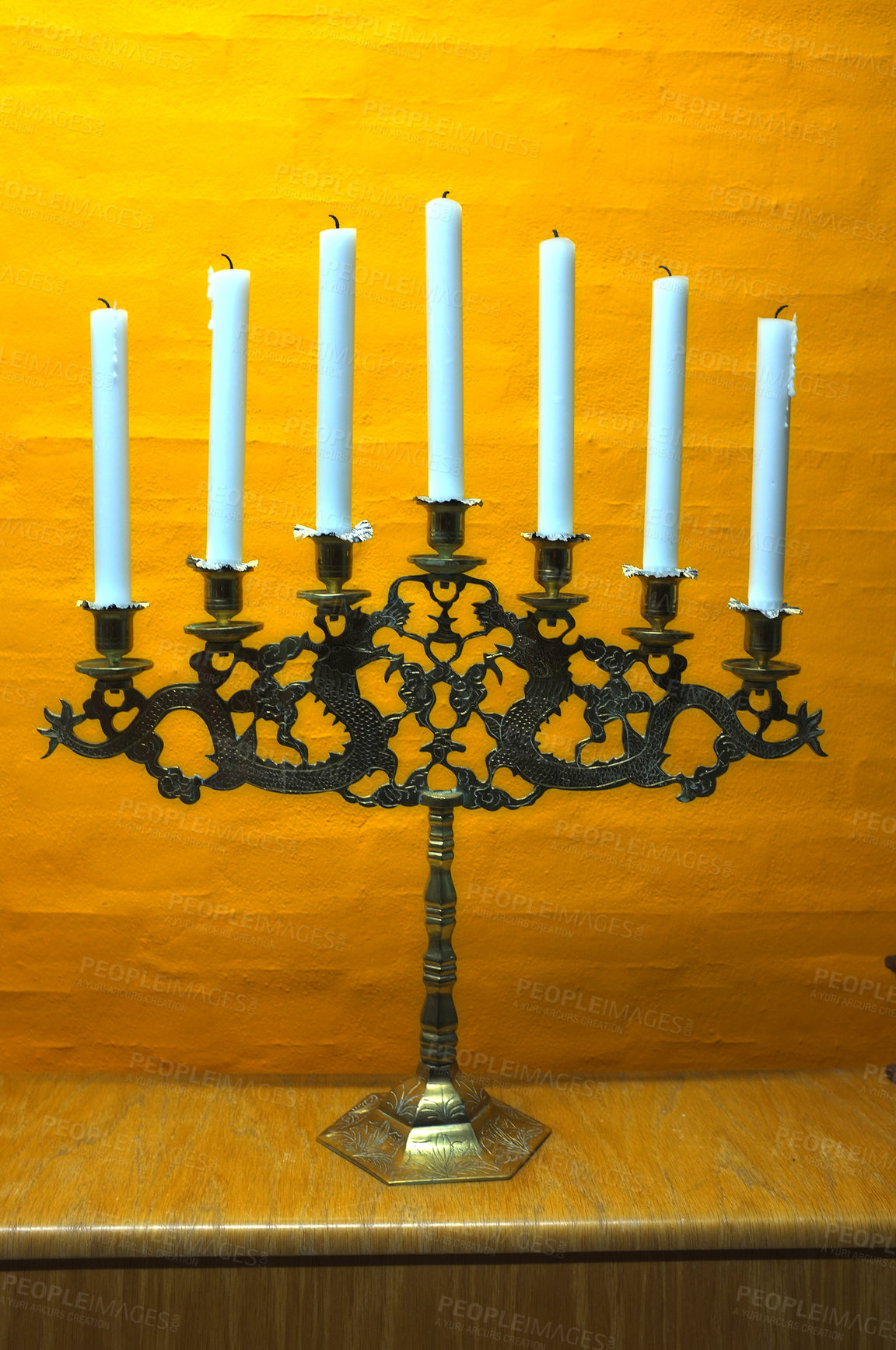 Buy stock photo Candle, vintage and holder in church on table at interior of room or cathedral. Wax, brass and retro candlestick for decoration at temple, wood and copper metal with antique candelabra for lighting