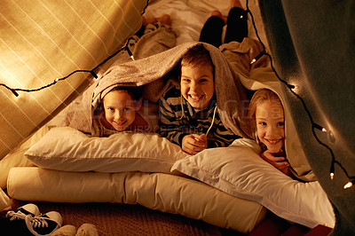 Buy stock photo Shot of three young children playing in a tent together