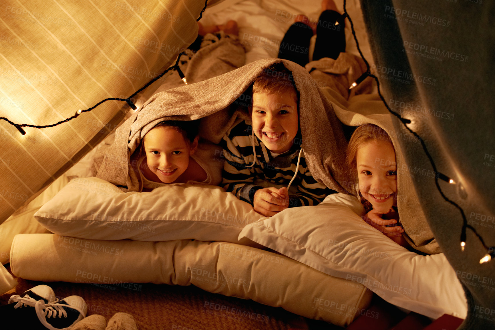 Buy stock photo Shot of three young children playing in a tent together