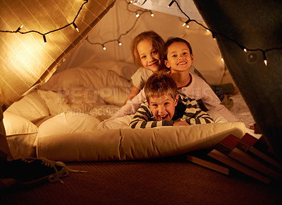 Buy stock photo Shot of three young children in a blanket fort