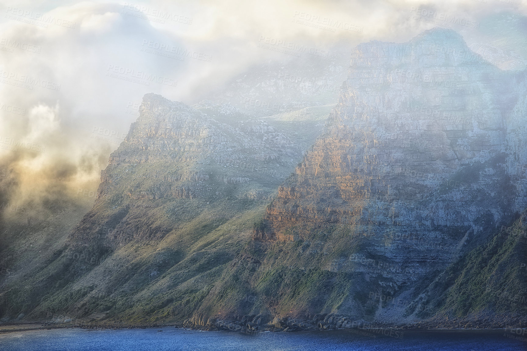 Buy stock photo Mountain, clouds and fog at ocean cliff with natural landscape, hill and calm beach at travel location. Nature, cloudy sky and sustainable environment with earth, sea and island holiday destination