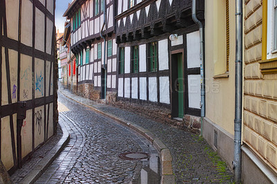 Buy stock photo Narrow, alley and building in road, Germany and historic cobble stone street or architecture in village for tourists. Structure or traditional design, creative home in old town real estate or path